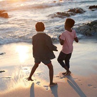 Two boys playing by the sea.